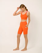Orange Biker shorts and sports bra for yoga, gym, workouts, running made by kosha yoga co from recycled materials