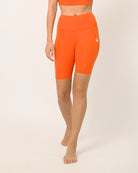 Orange knee length shorts for yoga and sports bra yoga set by kosha yoga co