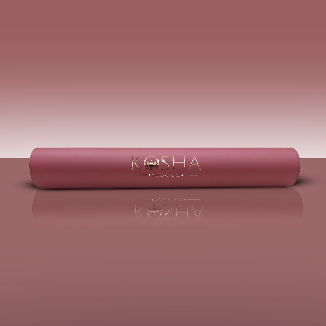 Pink yoga mat with 'KOSHA YOGA CO' branding on a matching pink background