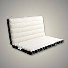 Ivory and black meditation cushion partly folded, showing how it folds in half