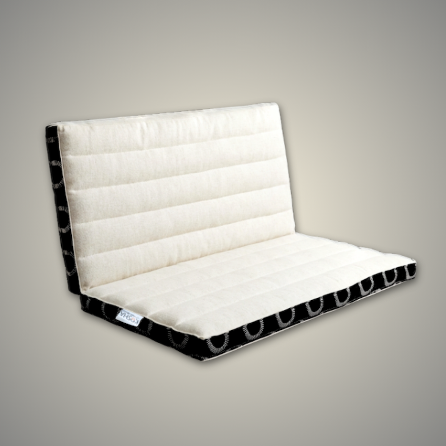 Ivory and black meditation cushion partly folded, showing how it folds in half