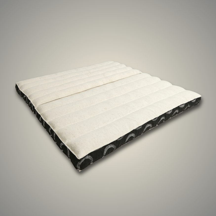 Ivory and black Kosha foldable meditation cushion lying open, showing its quilted cotton top