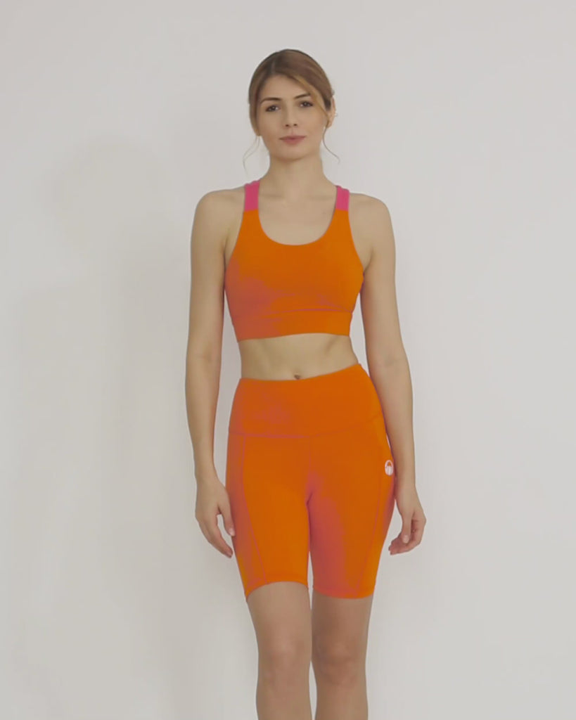Orange Biker shorts and sports bra co-ord set by kosha yoga co from recycled materials