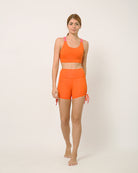 Orange yoga shorts and sports bra for yoga, gym, workouts, running made by kosha yoga co from recycled materials