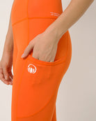 Orange moisture wicking yoga pants with two pockets by Kosha yoga co